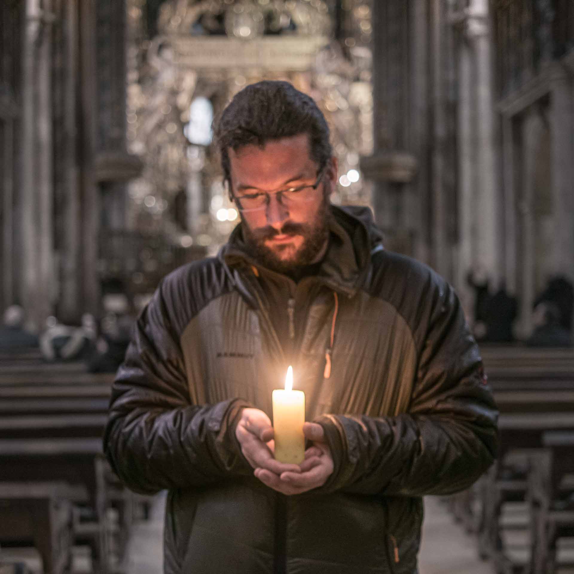 A man holding a candle in a church.